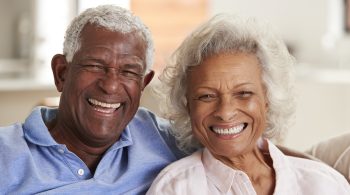 Portrait Of Loving Senior Couple Sitting On Sofa At Home Together